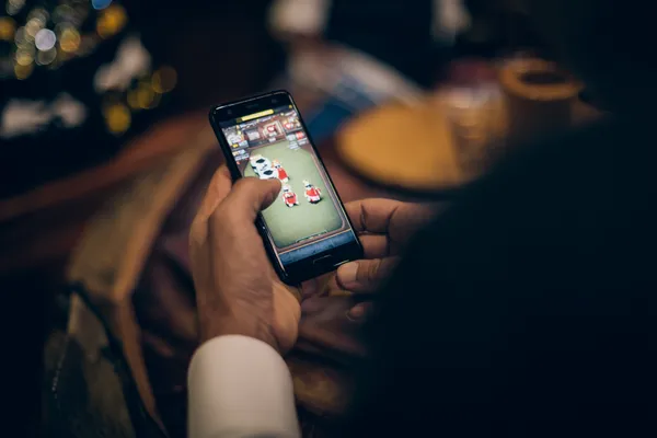 A man celebrating a winning moment on his laptop while gaming symbols float around him, capturing the excitement of JL77 games.